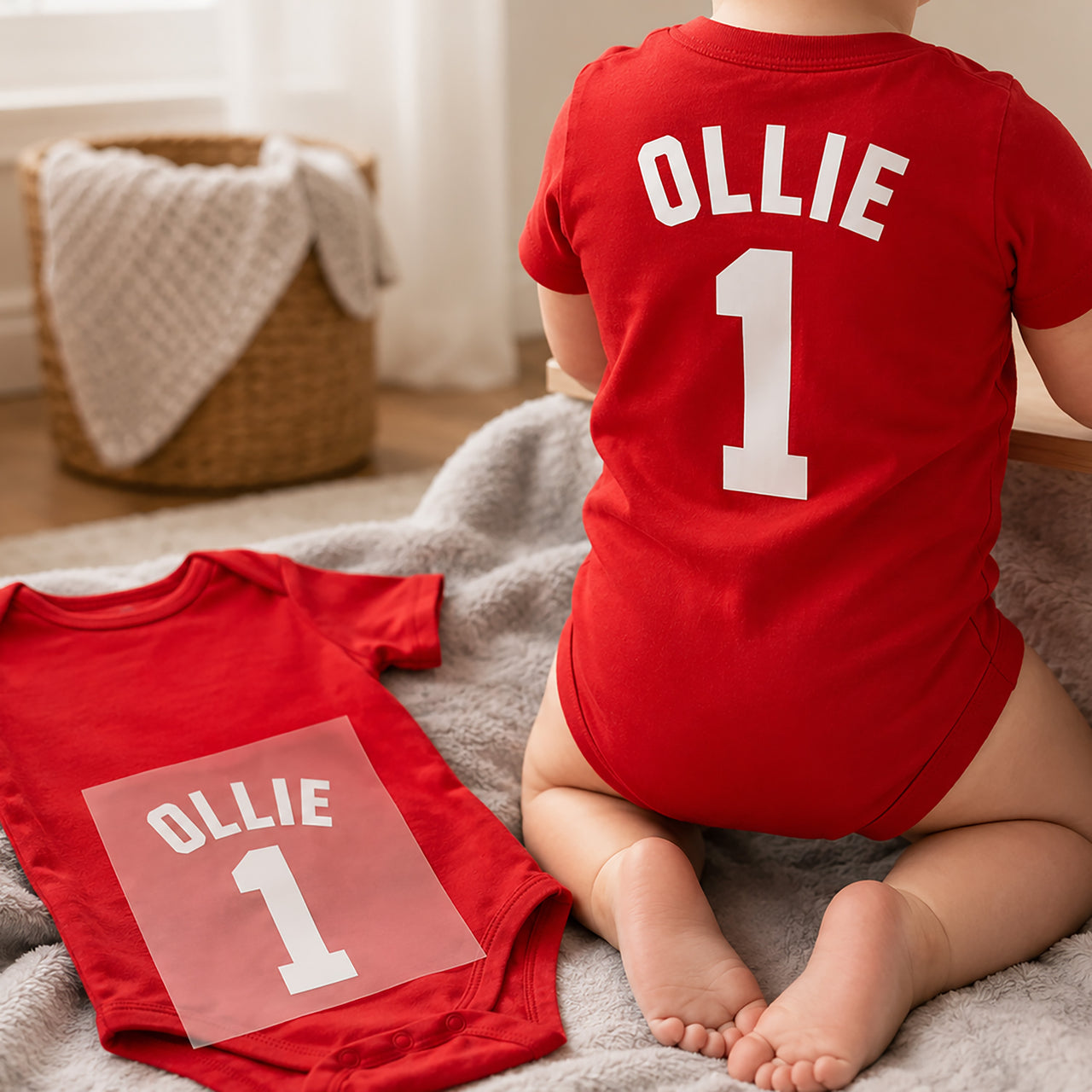 Baby Football Kit Name Number iron-on transfer: white OLLIE 1 on a red baby bodysuit, worn and as a transfer beside it