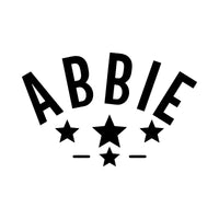 Flat black artwork on white: 'ABBIE' arched in capitals over four stars, custom name iron-on transfer