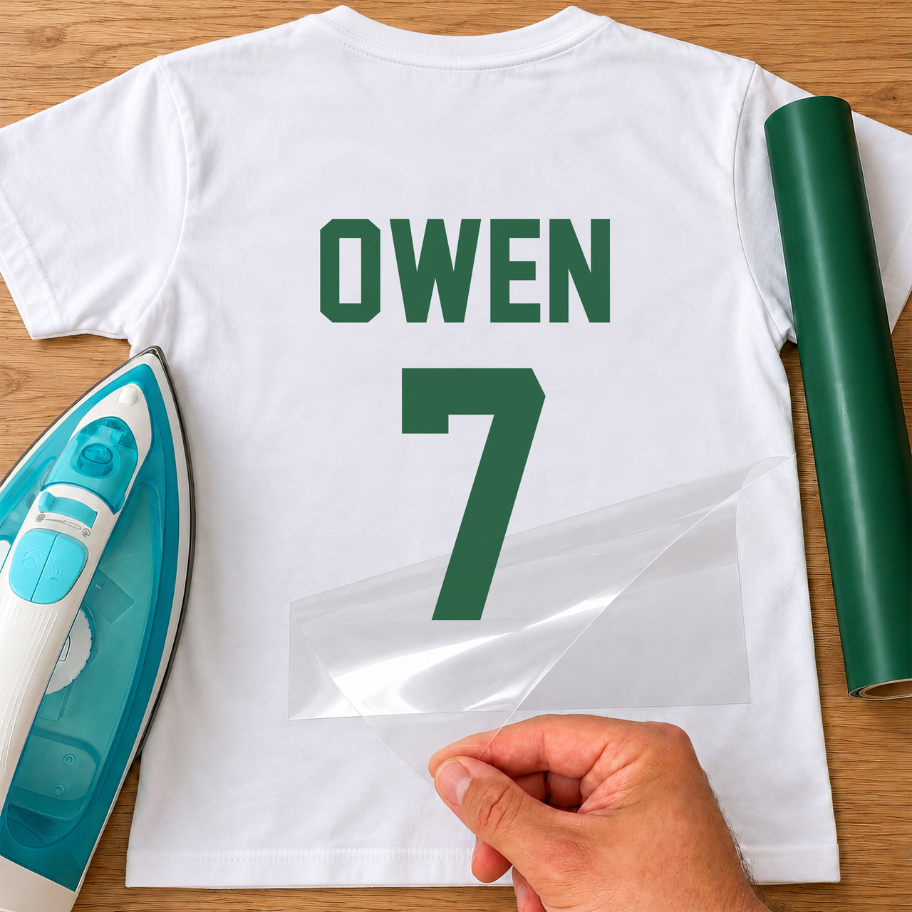 5-a-Side Football Name Number iron-on transfer: green OWEN 7 on a white T-shirt, film being peeled