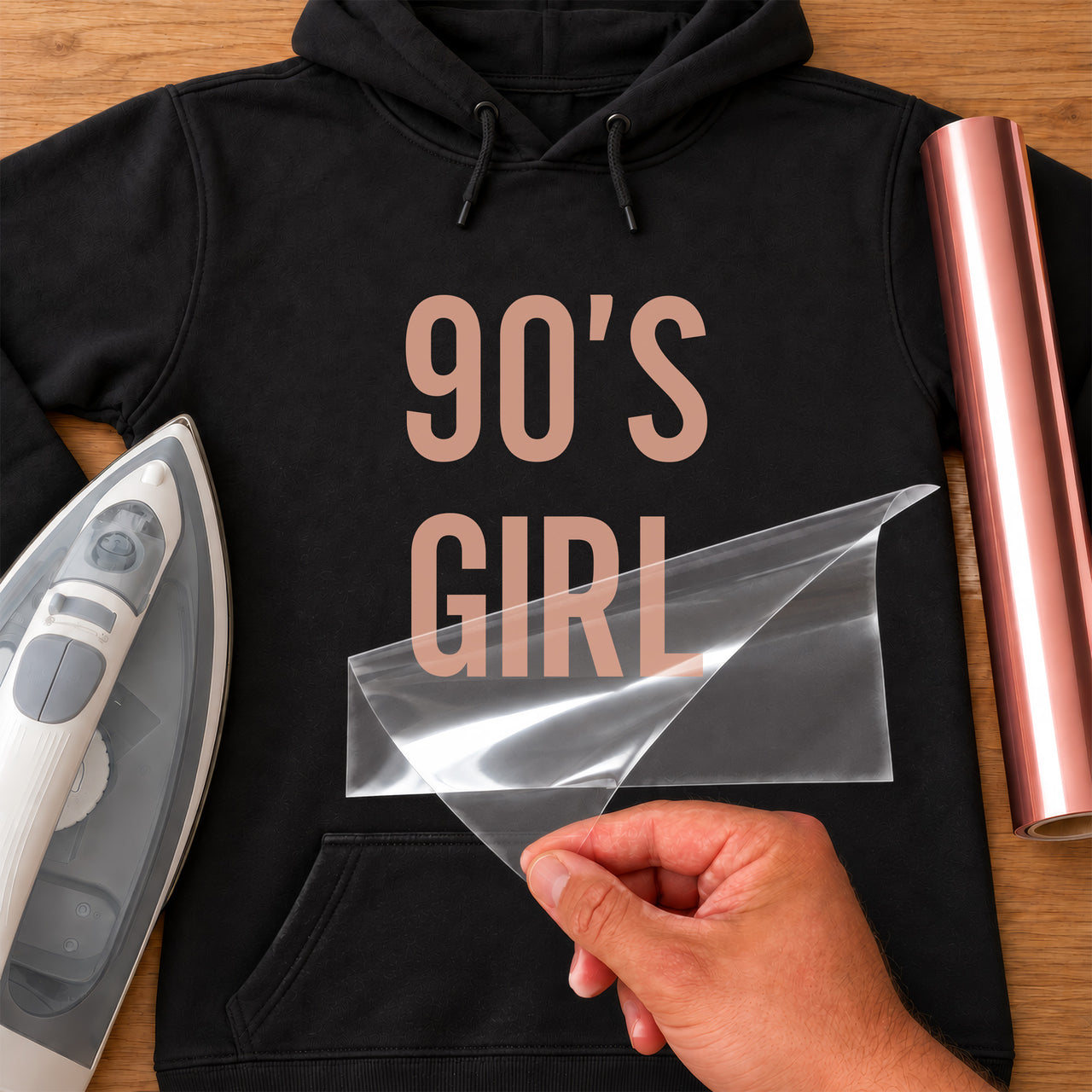Black hoodie with rose gold '90'S GIRL' iron-on transfer in tall capitals, iron and rose gold vinyl roll