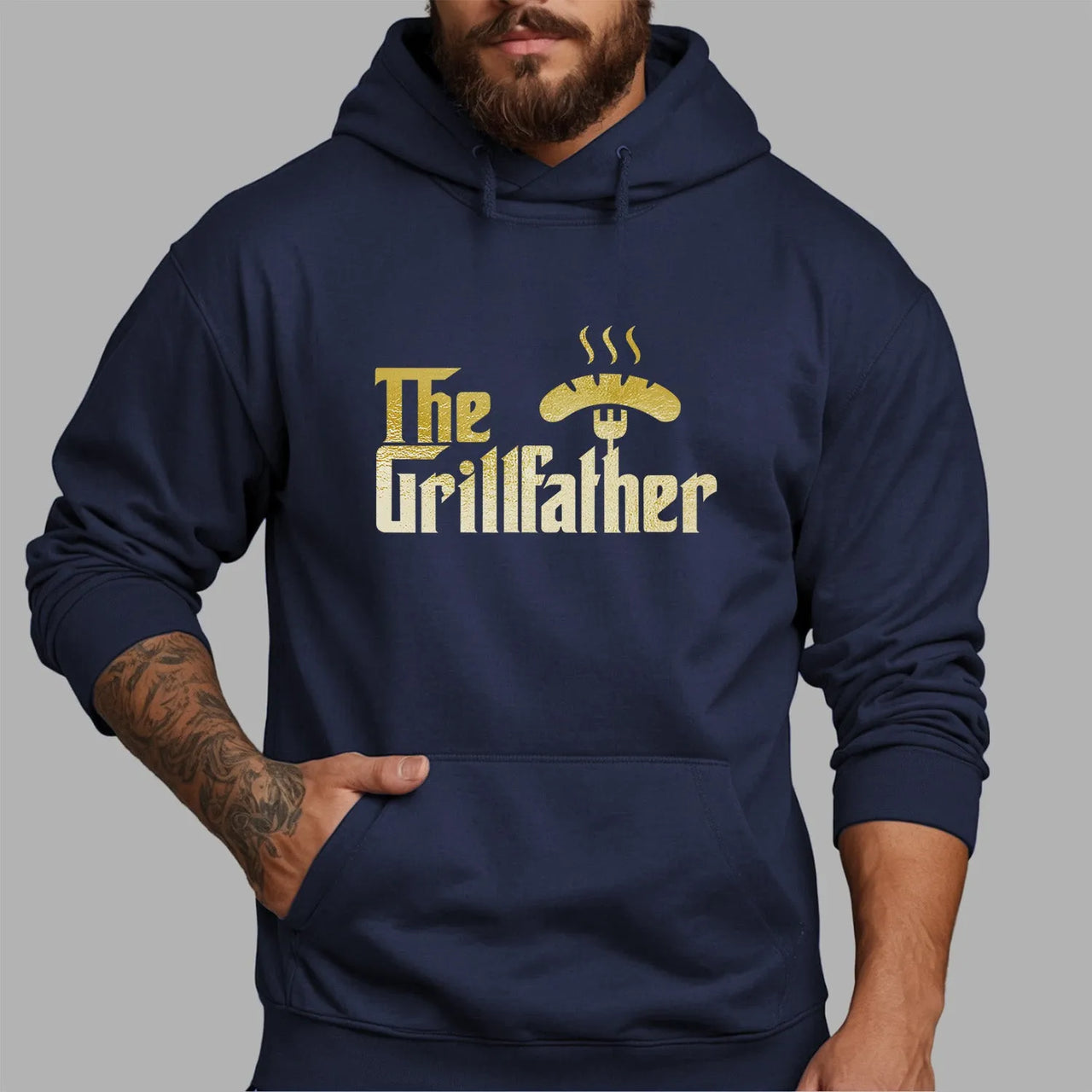 Man wearing BBQ Enthusiast Hoodie with "The Grillfather" motif, perfect for barbecue masters, made from soft cotton fabric.