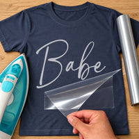 Navy T-shirt with silver iron-on vinyl script 'Babe', iron and vinyl roll beside