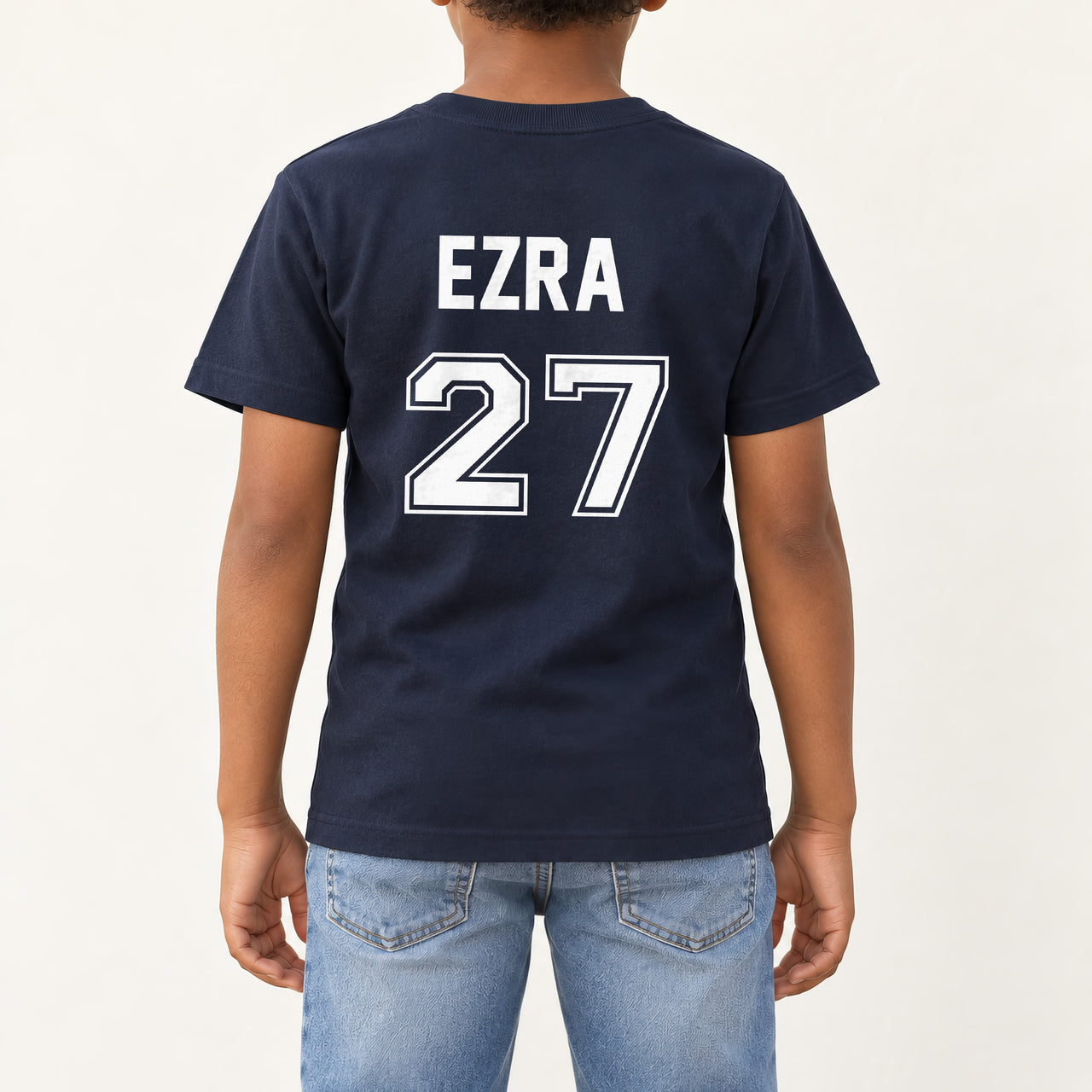 Baby Football Kit Name Number Iron-On Transfer, shown on a navy kids t-shirt (back view)
