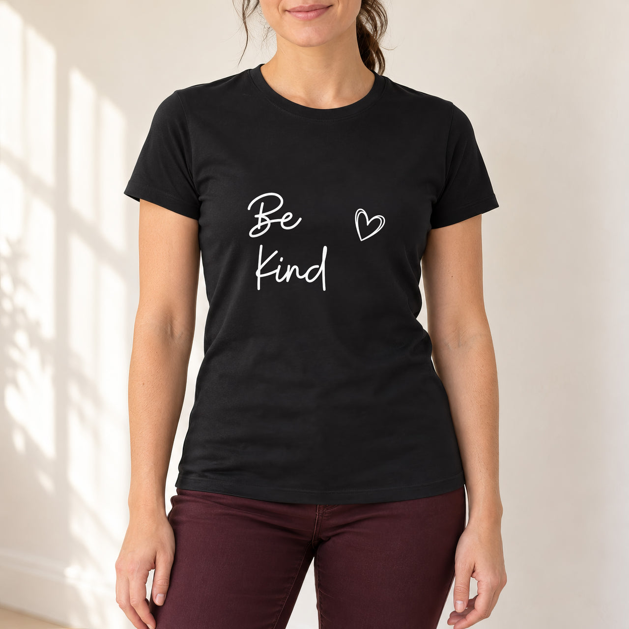 Black T-shirt with the Be Kind Script Heart design printed on the chest