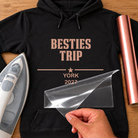 Black hoodie with rose gold iron-on vinyl reading 'BESTIES TRIP', a star, 'YORK 2027', iron and rose gold vinyl roll