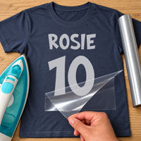 Birthday Age Number iron-on transfer: silver ROSIE 10 on a navy T-shirt, film being peeled