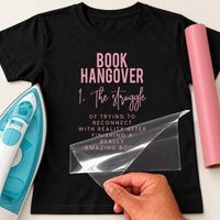 Black T-shirt with pink iron-on vinyl 'BOOK HANGOVER 1. The struggle' definition text, iron and pink vinyl roll