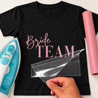 Black T-shirt with pink 'Bride TEAM' iron-on transfer in script and serif capitals, iron and pink vinyl roll