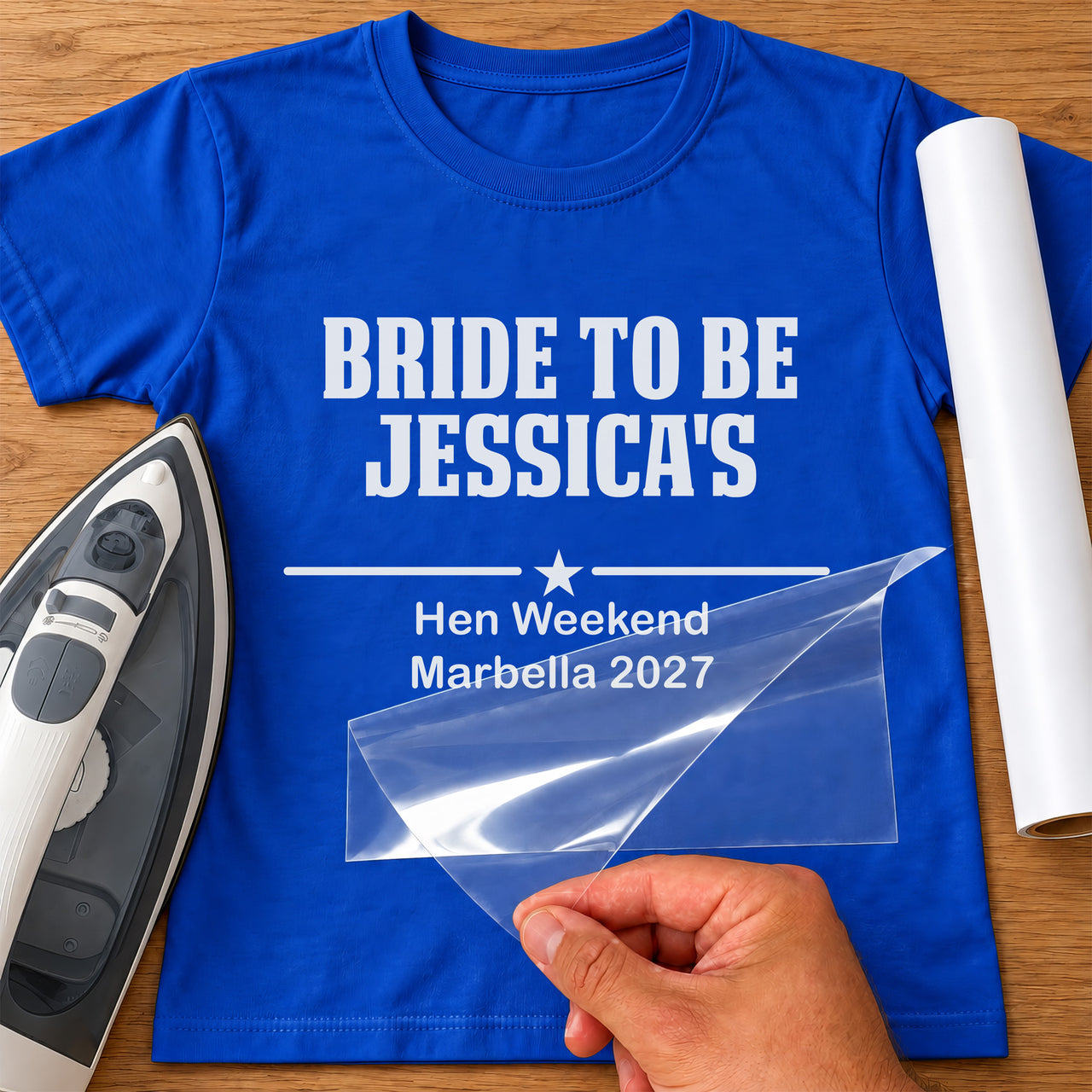 Royal blue T-shirt with white vinyl 'BRIDE TO BE JESSICA'S' and 'Hen Weekend Marbella 2027', mockup with iron