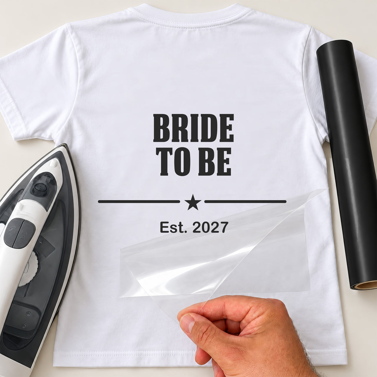 Back of a white T-shirt with black 'BRIDE TO BE', star divider and 'Est. 2027', hen party iron-on transfer