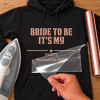 Black hoodie with rose gold iron-on vinyl 'BRIDE TO BE IT'S MY PARTY Newcastle 2027' with star