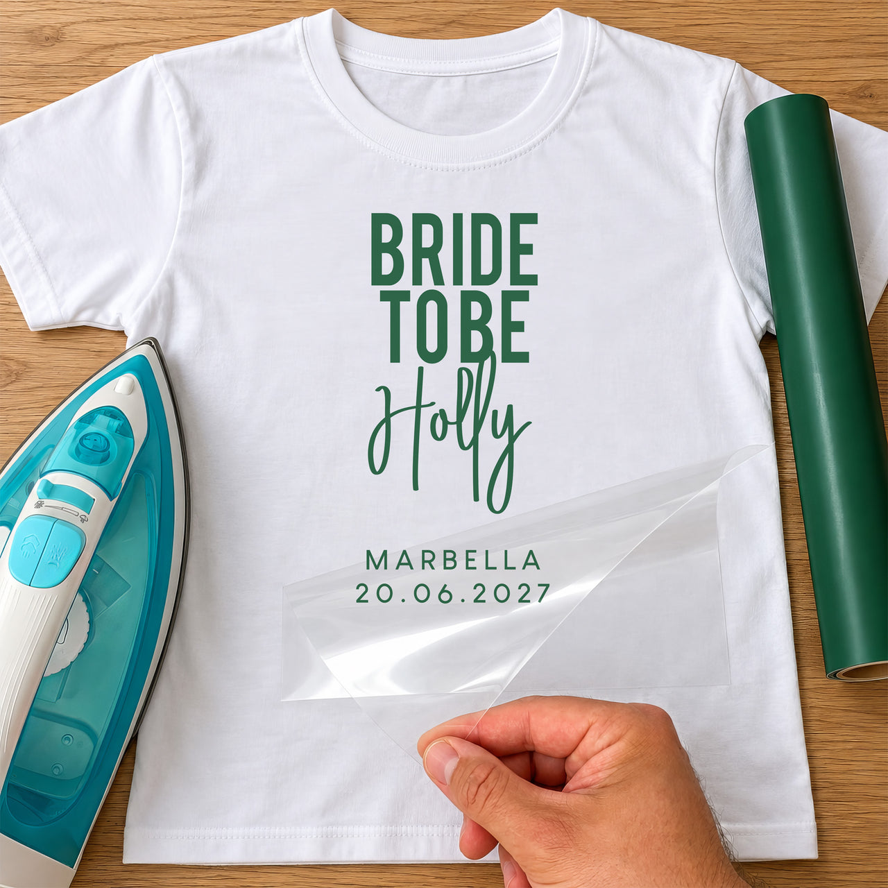 White T-shirt with green 'BRIDE TO BE' bold capitals, 'Holly' script and 'MARBELLA 20.06.2027', iron and green vinyl roll