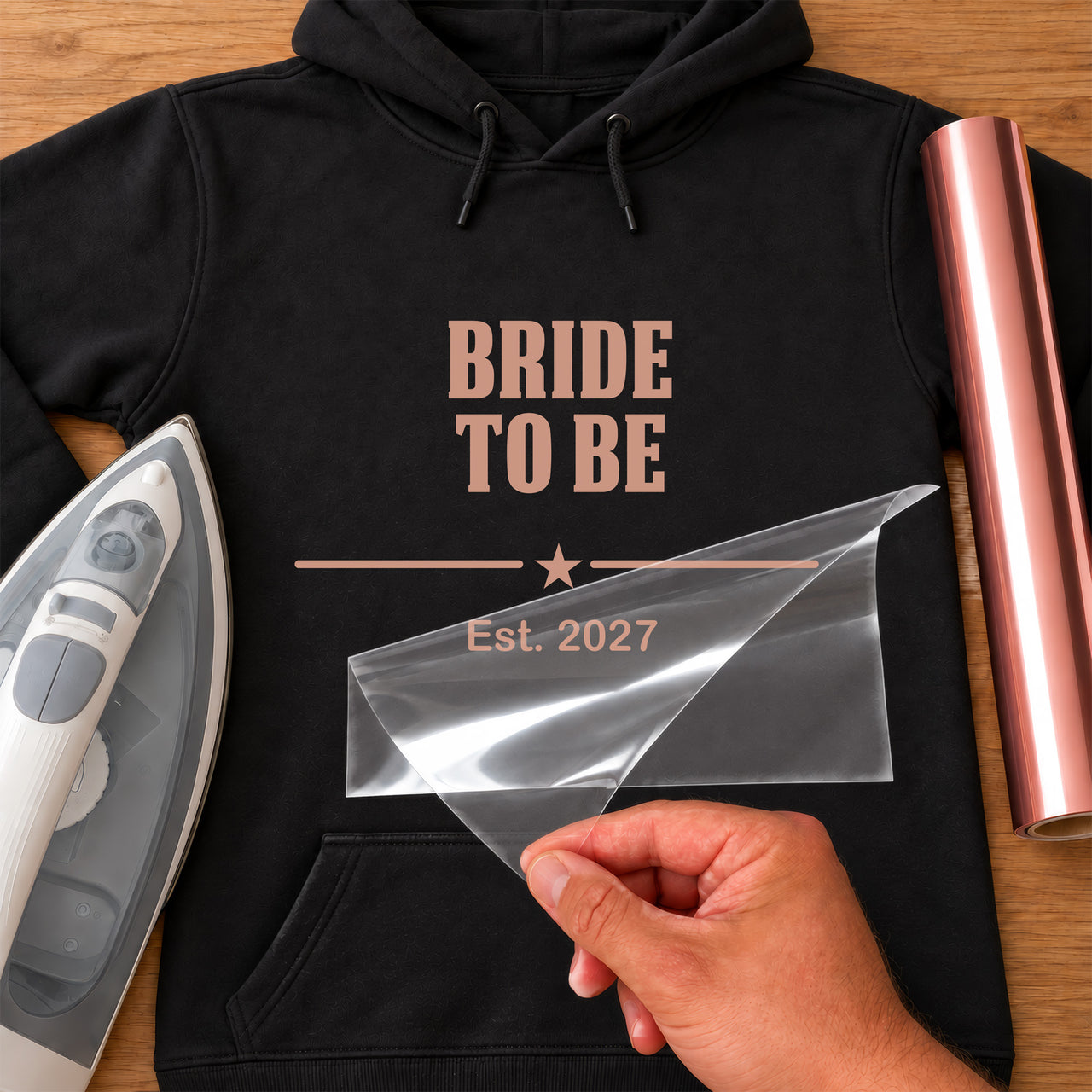 Black hoodie with rose gold 'BRIDE TO BE', star divider and 'Est. 2027', Bride To Be Varsity iron-on transfer