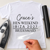 White tee back mockup with black vinyl 'Grace's Hen Weekend Ibiza 2027' and 'Bridesmaid' under a rule