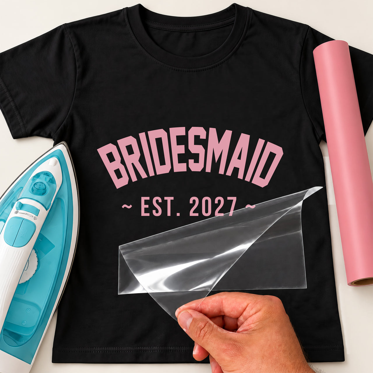 Black T-shirt with pink arched varsity 'BRIDESMAID' and '~ EST. 2027 ~', bridesmaid iron-on transfer