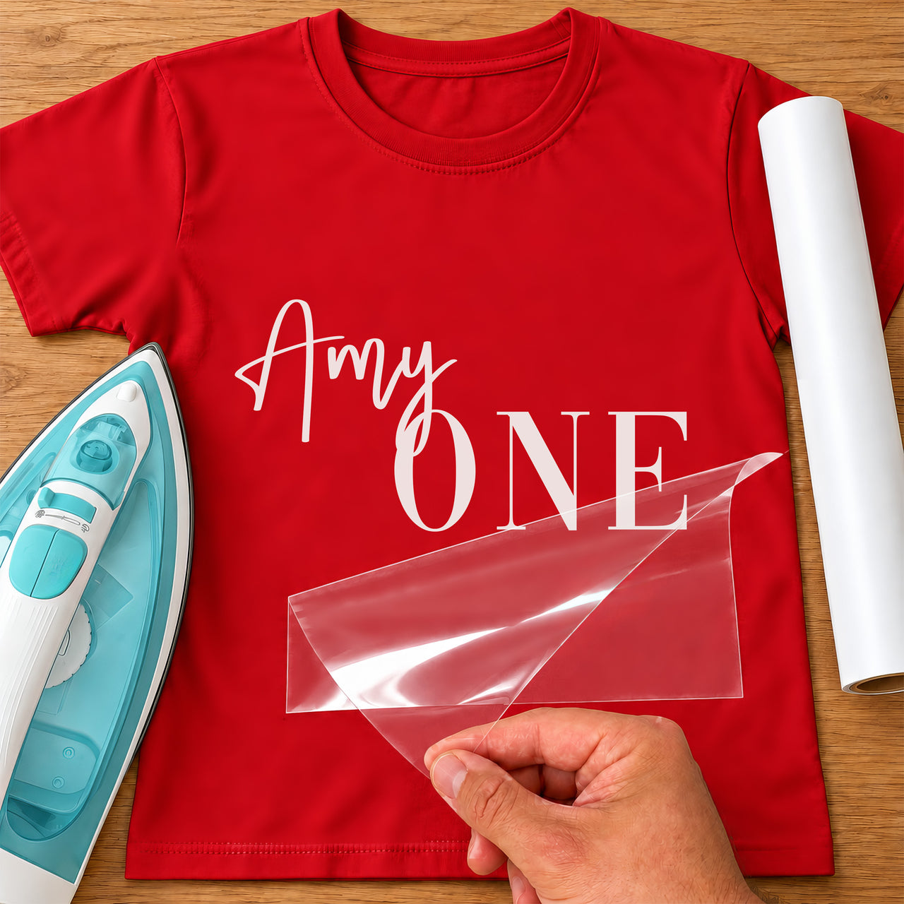 Cake Smash First Birthday iron-on transfer: white Amy ONE on a red T-shirt, film being peeled