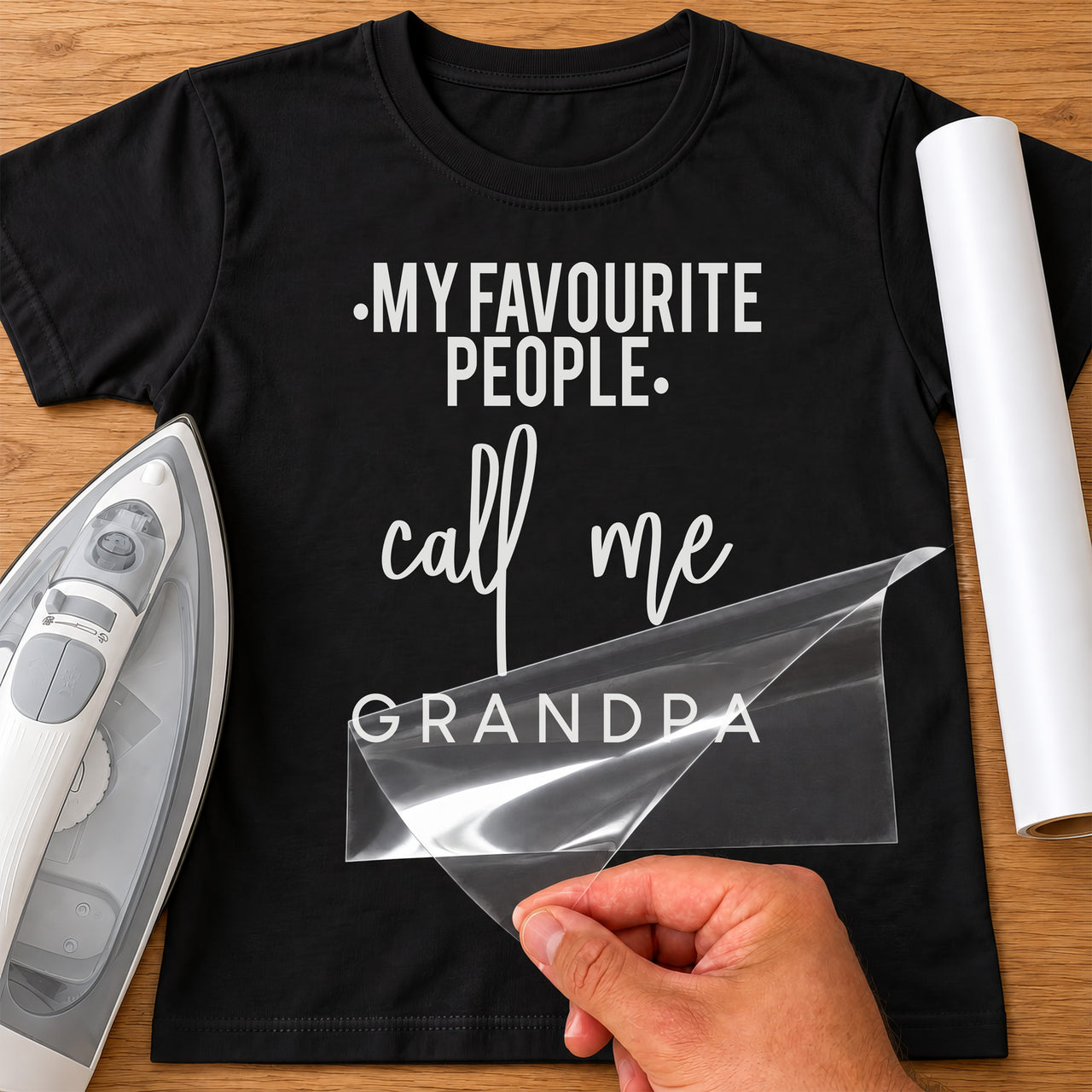 Black T-shirt with white 'MY FAVOURITE PEOPLE call me GRANDPA' iron-on transfer in mixed fonts, iron and white vinyl roll