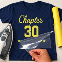 Mockup: navy tee with yellow vinyl script 'Chapter' over a big '30' and two stars, film being peeled off