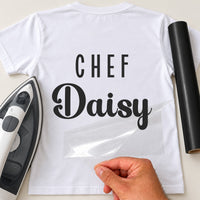 White T-shirt mockup with 'CHEF' in spaced capitals over script 'Daisy', carrier sheet being peeled away