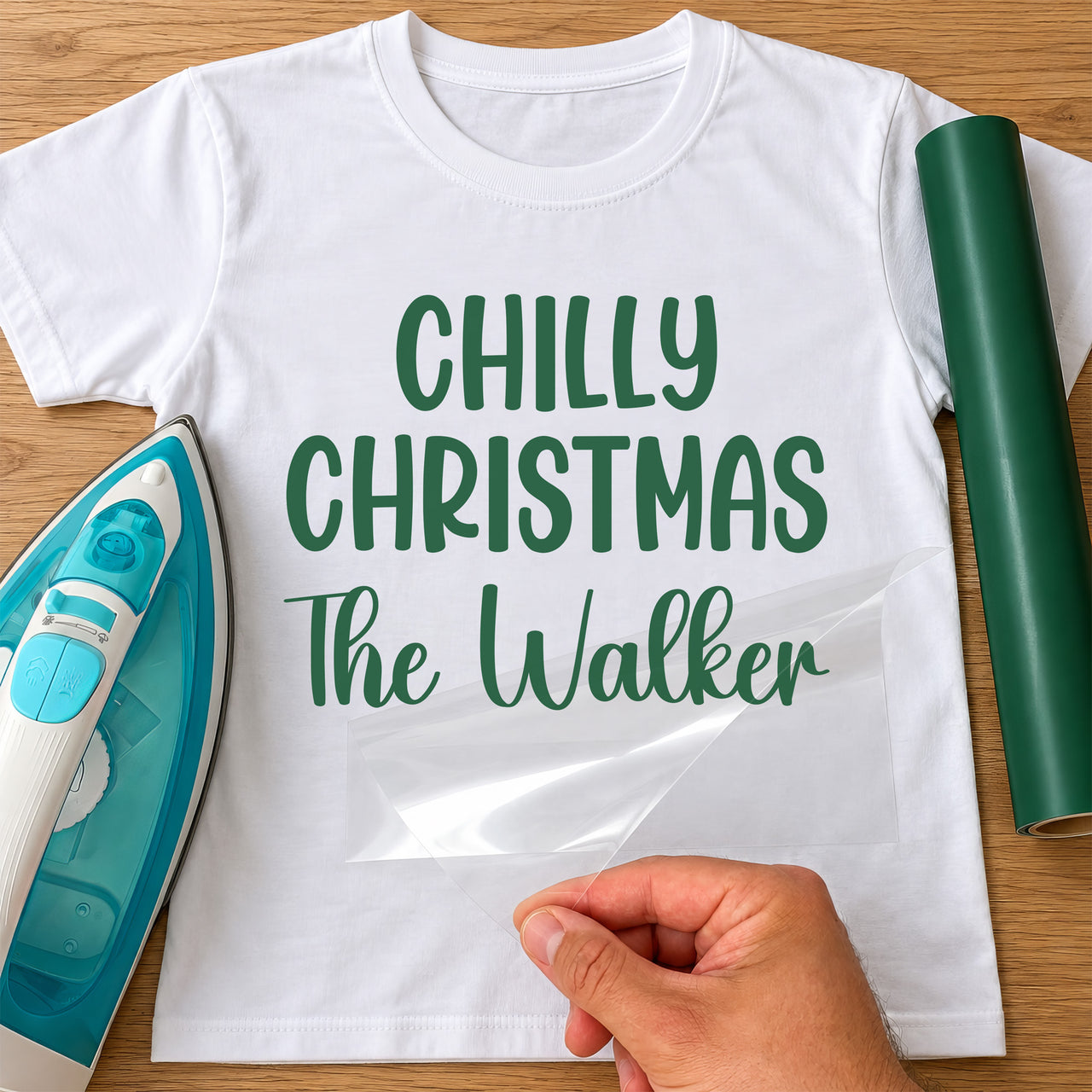 Chilly Christmas iron-on transfer: green CHILLY CHRISTMAS The Walker on a white T-shirt, film being peeled