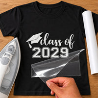 Black T-shirt with white 'class of 2029' lettering and graduation cap, carrier film being peeled off - iron-on vinyl transfer