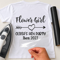 Mockup: white tee with script 'Flower Girl', heart arrow and 'OLIVIA`S HEN PARTY Ibiza 2027', iron and black vinyl roll