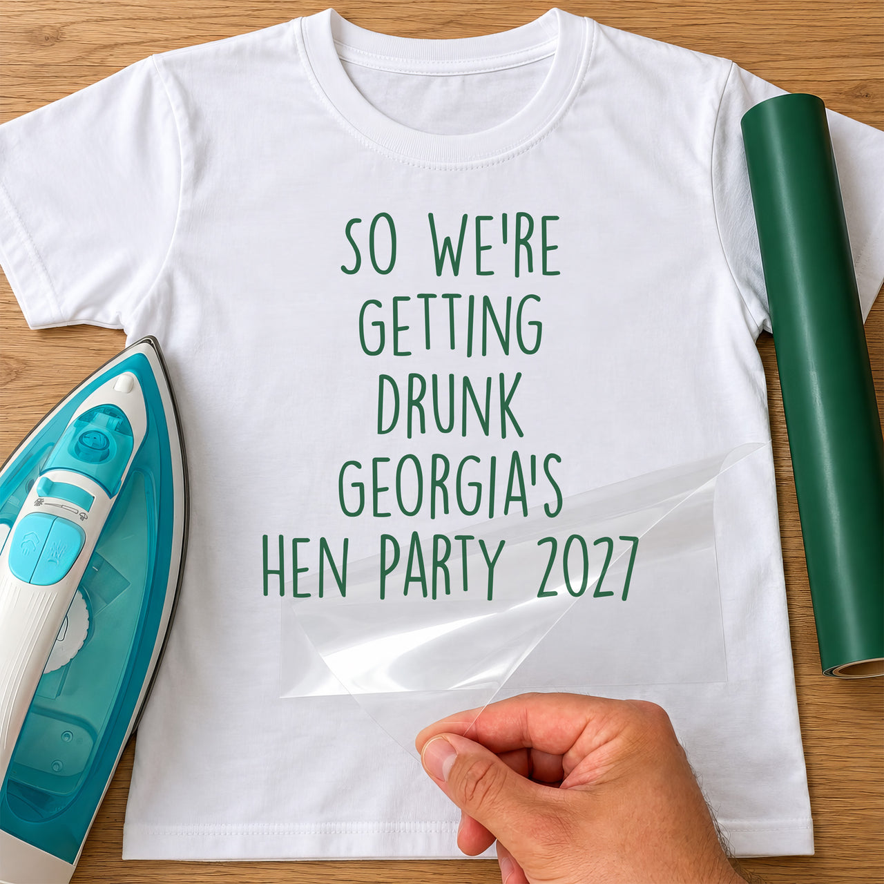 Mockup: white tee with green vinyl 'So we're getting drunk', a sample bride's name and 'hen party 2027'