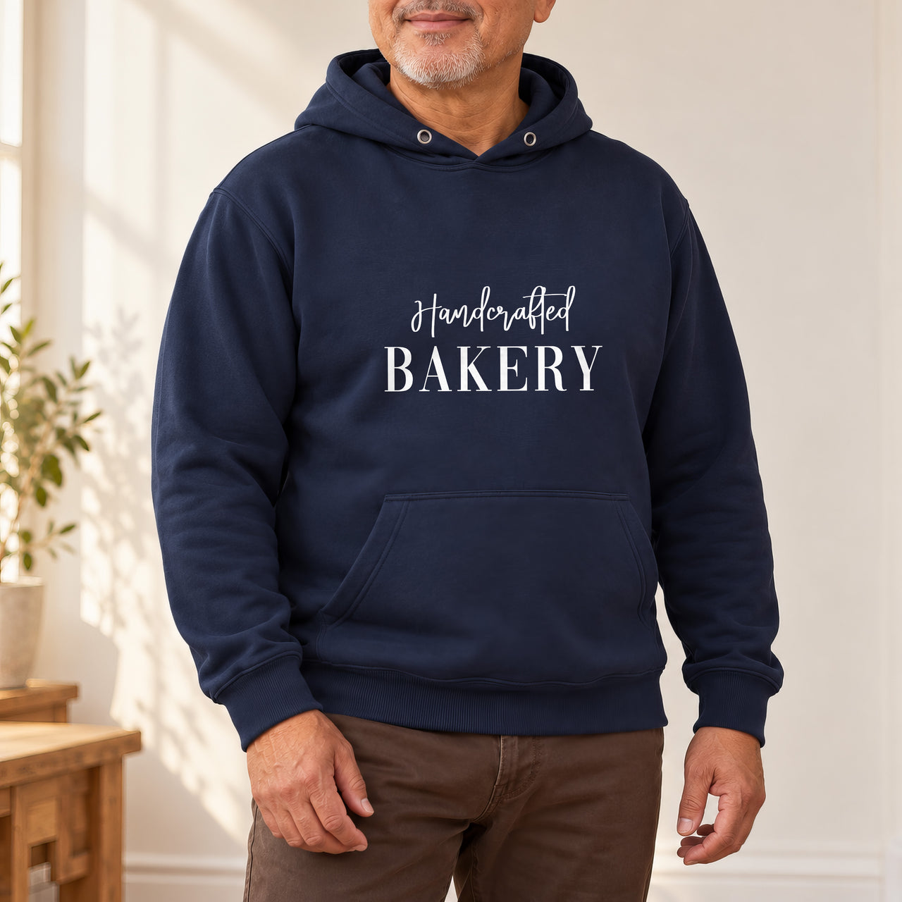 Navy hoodie with the Handcrafted Bakery design printed on the chest