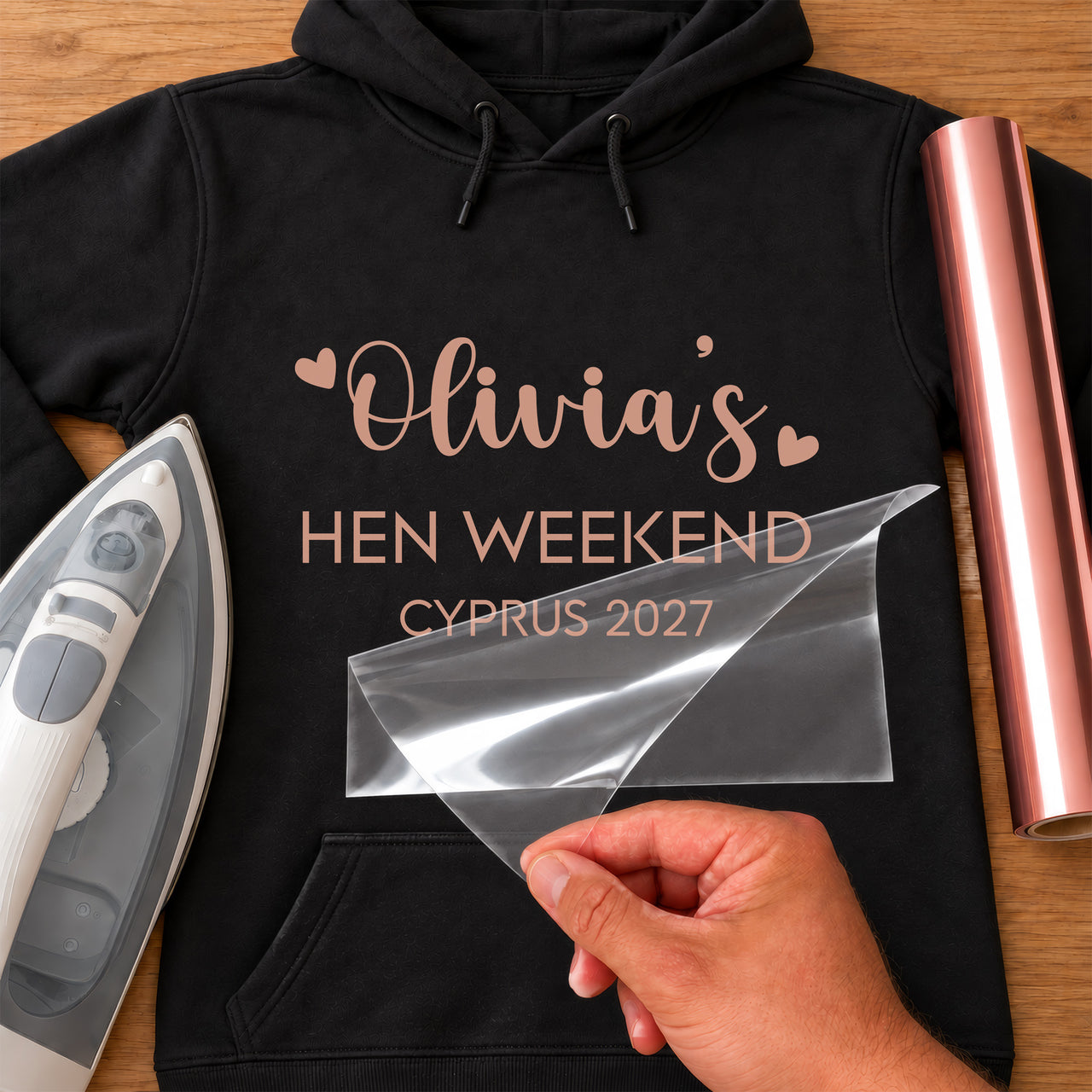 Black hoodie with rose gold iron-on vinyl 'Olivia's HEN WEEKEND CYPRUS 2027' with hearts