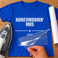 Royal blue T-shirt with white 'HONEYMOONIN' MRS' and '2027' iron-on transfer, star divider, iron and vinyl roll