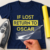 Navy T-shirt with yellow iron-on vinyl reading 'IF LOST RETURN TO OSCAR', iron and yellow vinyl roll beside