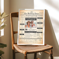 Silver framed Pearl anniversary newspaper style poster standing on a wooden chair with a woven seat