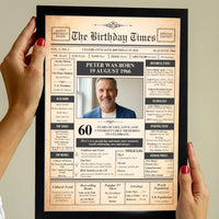 Hands with red nails holding a black framed 60th birthday front page poster with a photo of a smiling man