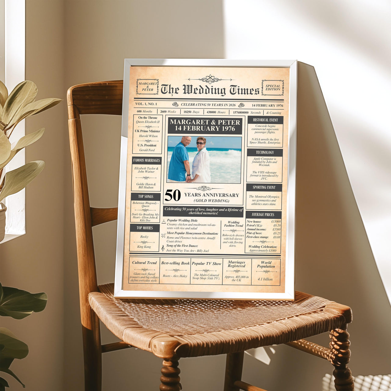 Personalised golden anniversary newspaper poster in a silver frame resting on a wooden chair in sunlight