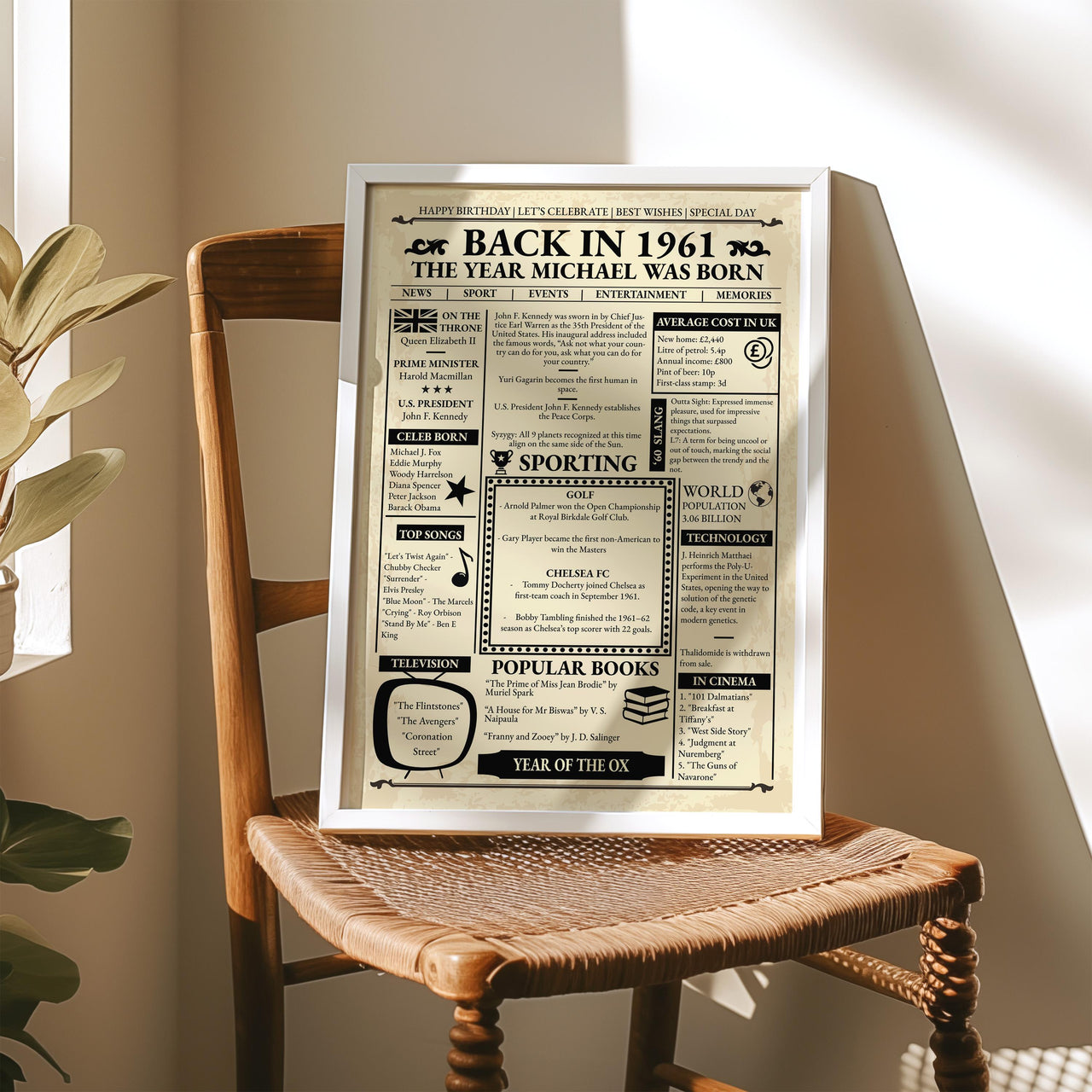 Silver framed 1961 front page style poster on a wooden chair with a woven seat