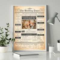 Framed 60 years anniversary newspaper poster on a white desk beside a plant, lamp and pencil pot
