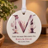 Mum ornament: ceramic disc with a floral letter M and This Mummy Belongs To Raya & Ollie, We Love You