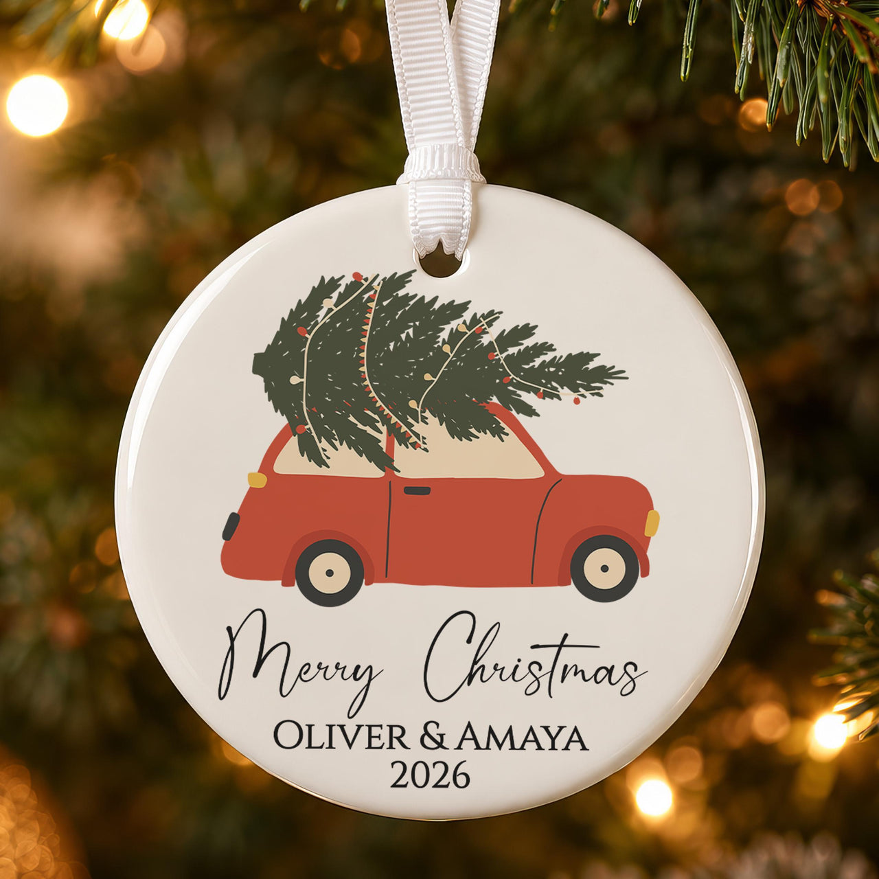 Personalised Christmas bauble: ceramic ornament with a red car carrying a tree, Merry Christmas and Oliver & Amaya 2026