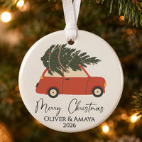 Personalised Christmas bauble: ceramic ornament with a red car carrying a tree, Merry Christmas and Oliver & Amaya 2026