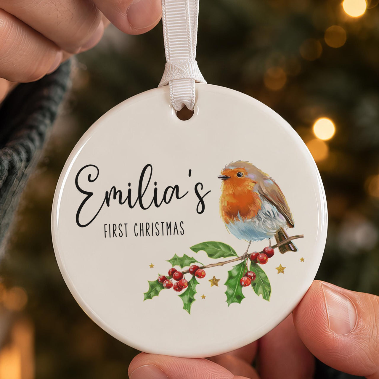 First Christmas bauble: ceramic ornament with a watercolour robin on holly and Emilia's First Christmas