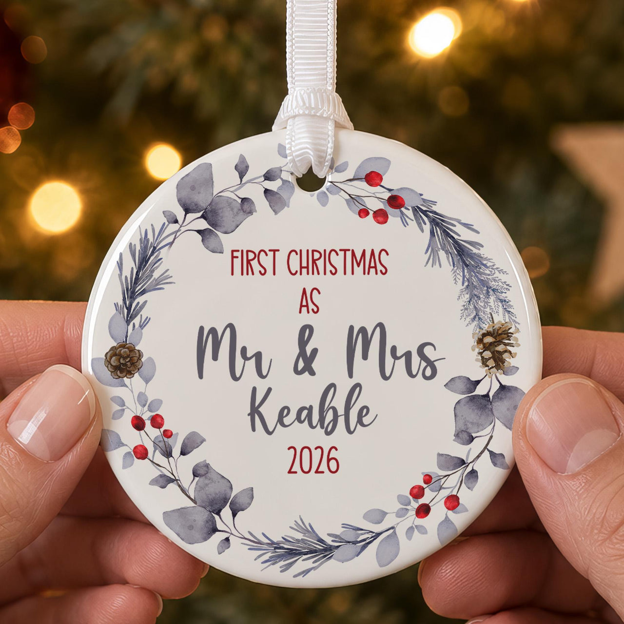 First Christmas married bauble: ceramic ornament with a blue-grey winter wreath, berries and Mr & Mrs Keable 2026