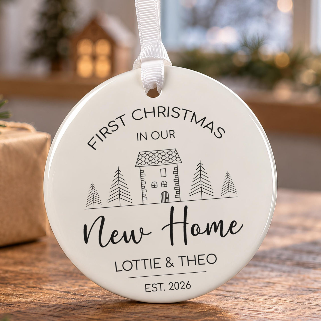 New home Christmas bauble: ceramic ornament with a line-art house between pine trees, New Home and Lottie & Theo