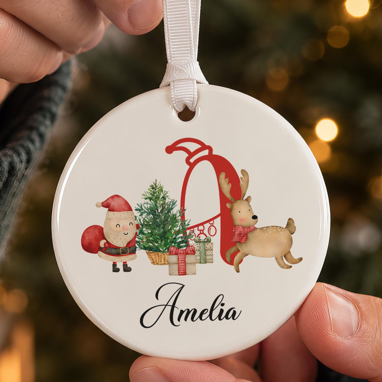 Red initial ceramic bauble: big red letter A with Santa, a tree, gifts and a reindeer above the name Amelia