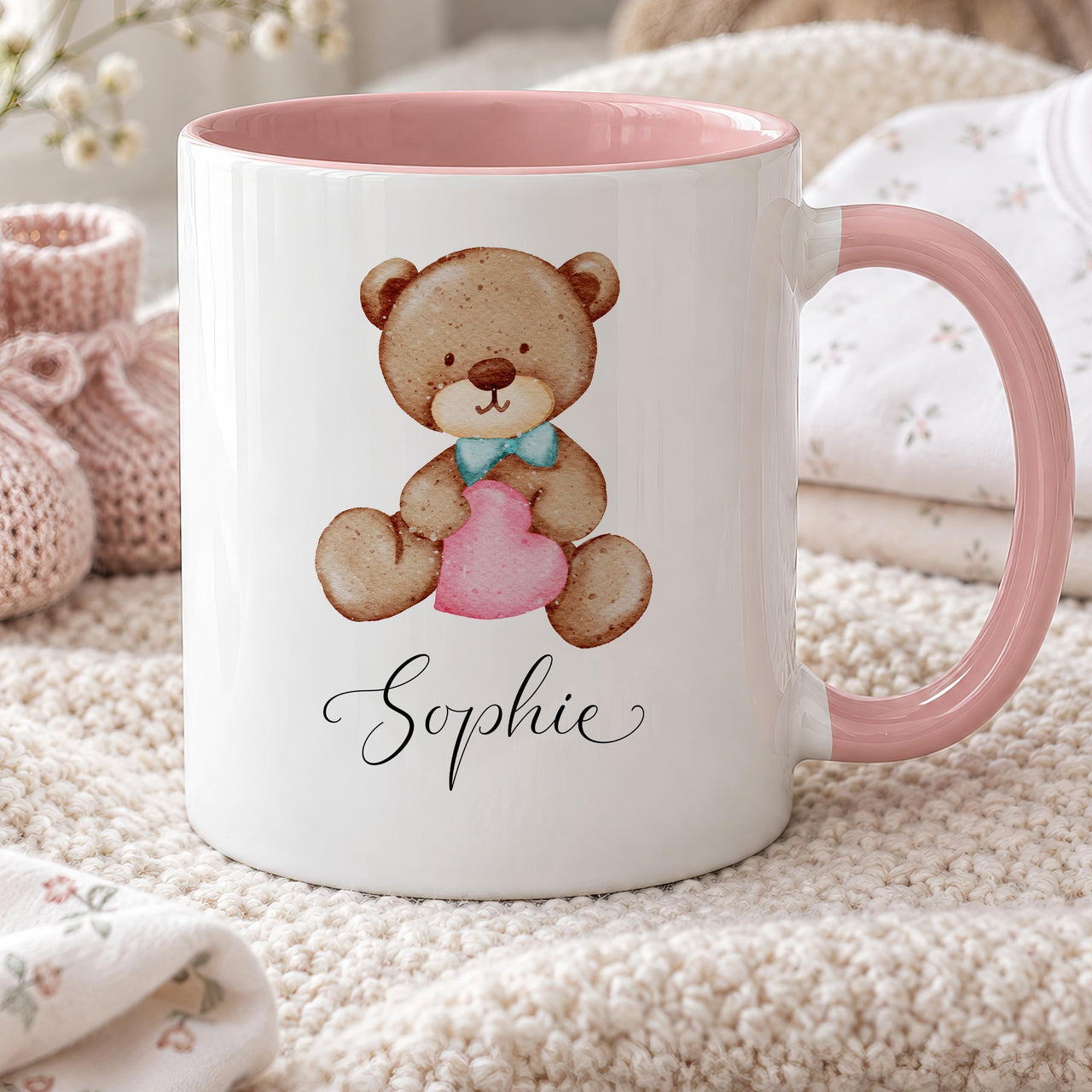 Personalised bear mug: white mug with pink handle, a watercolour teddy in a blue bow tie holding a heart, name Sophie