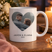 White mug with a couple's photo inside a heart and the names Jaxon and Eliana with 2025 below