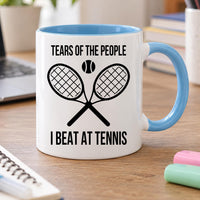 Tennis mug: white mug with light blue handle and inside, crossed rackets and ball, Tears of the People I Beat at Tennis