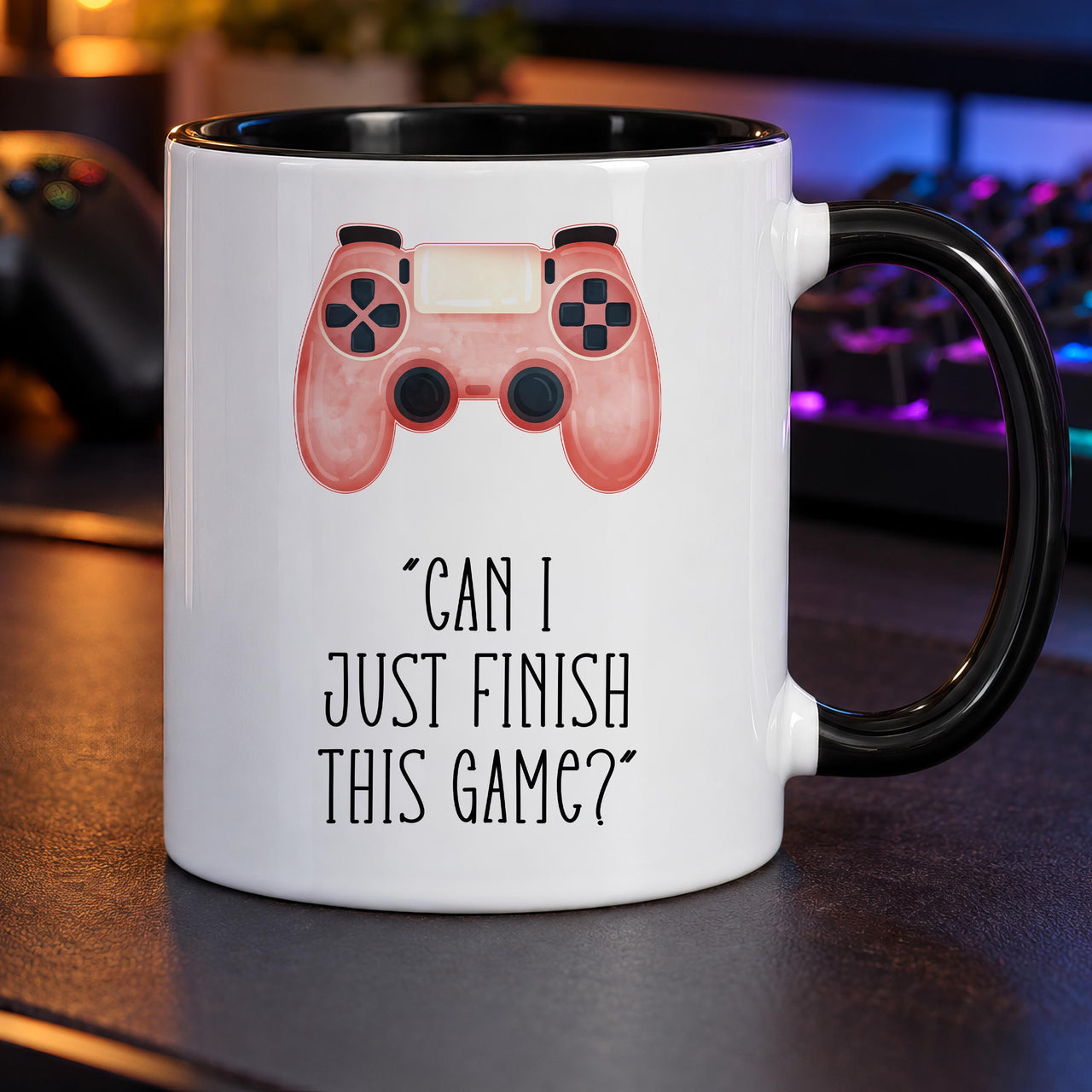 Gamer mug: white mug with black handle and inside, a pink watercolour game controller and Can I just finish this game?