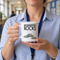 Teacher in a school corridor holding a Geography Rocks mug