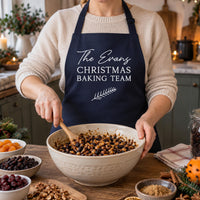 Navy apron reading 'The Evans CHRISTMAS BAKING TEAM', mixing Christmas pudding fruit - personalised apron