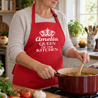 Red apron with white crown and 'Amelia QUEEN OF THE KITCHEN', stirring stew - personalised apron